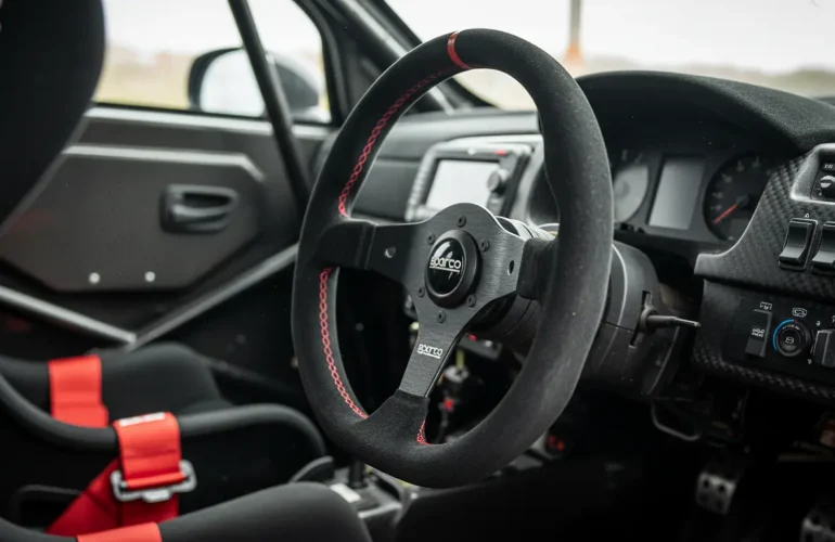 Volant de rallye Sparco compact dans un cockpit de compétition avec harnais FIA